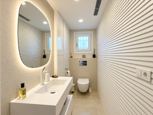 Baño minimalista con espejo iluminado
