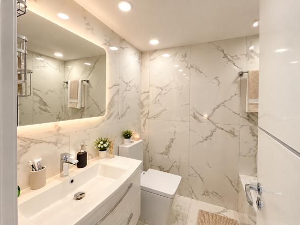 Baño moderno con mármol y luz cálida (1)