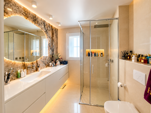 Baño moderno con mármol y luz cálida