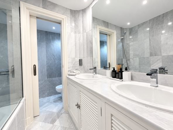 Baño moderno de mármol y doble lavabo