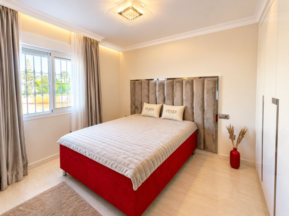 Dormitorio de lujo con cama roja y FENDI