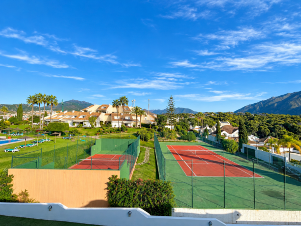 Panorámica de resort con pistas de tenis y montañas